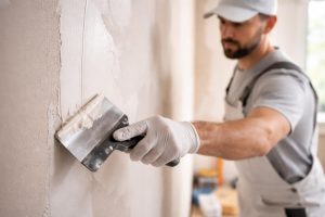 professionnel-enduit-spatule-mur-renovation